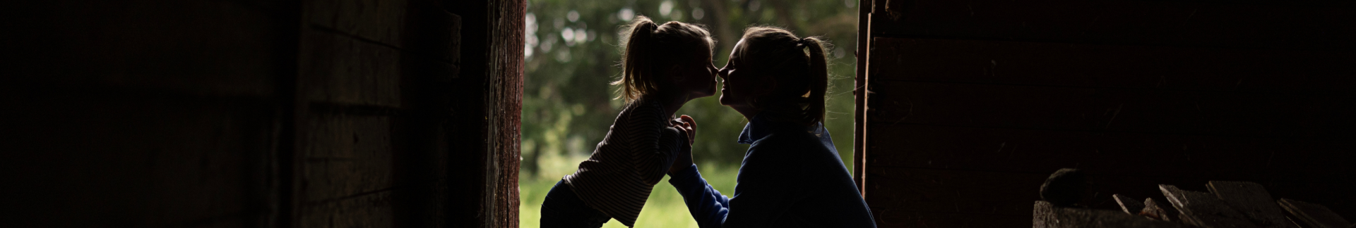 mother and daughter sharing a sweet moment in a barn